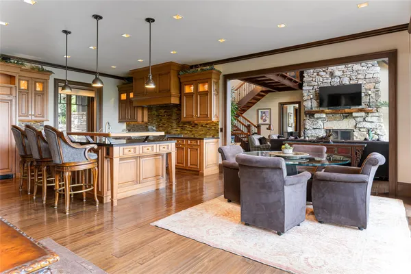 a kitchen with stainless steel appliances kitchen island granite countertop a stove a sink a dining table and chairs
