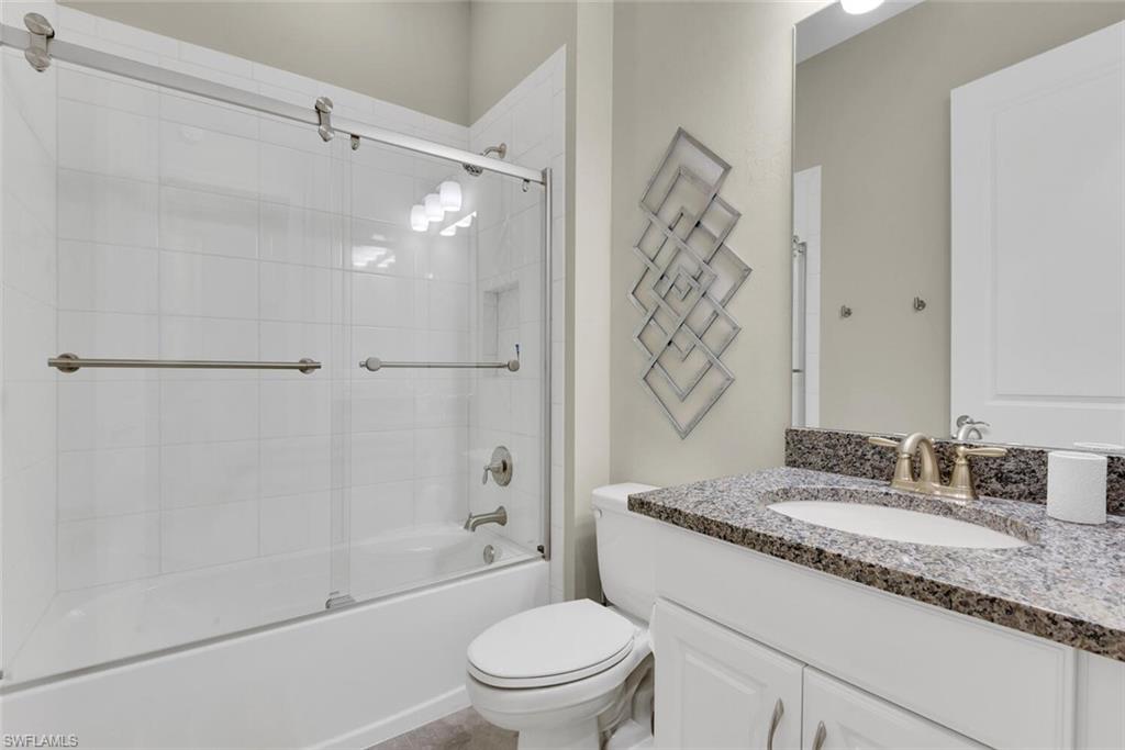 9630 Campanile Circle Naples, FL 34114 - Photo 22 of 31 a bathroom with a granite countertop sink a toilet and shower