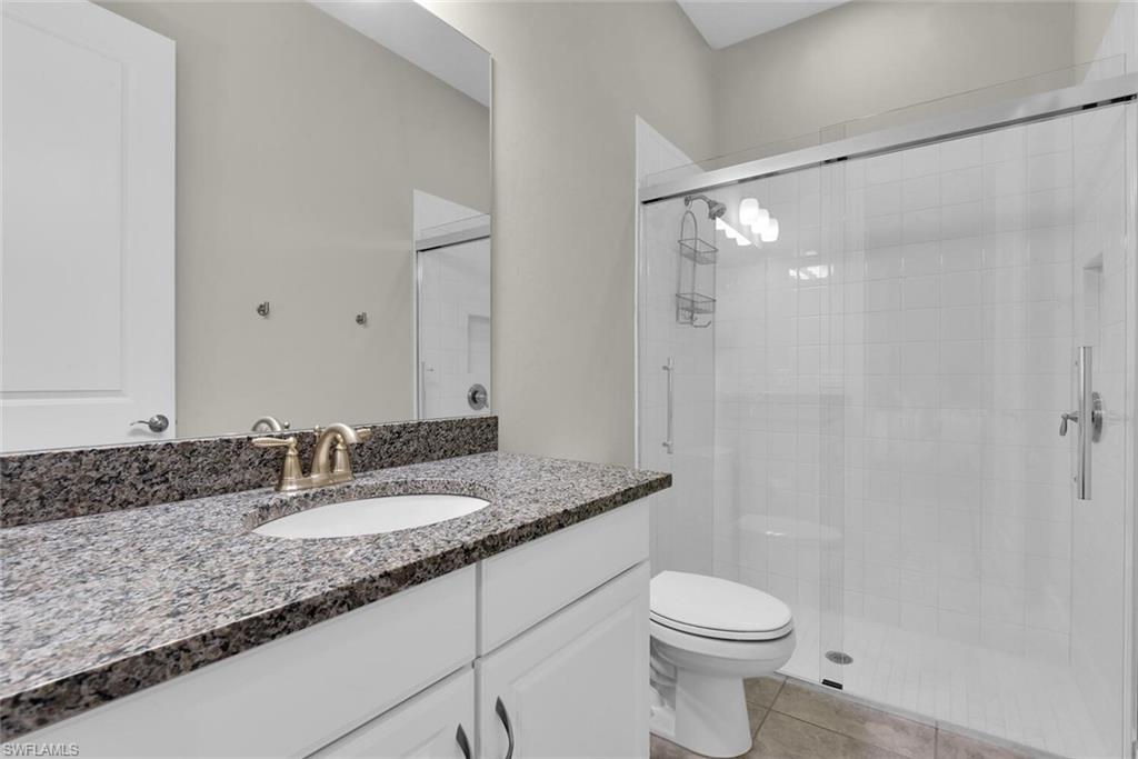 9630 Campanile Circle Naples, FL 34114 - Photo 25 of 31 a bathroom with a granite countertop sink toilet and shower
