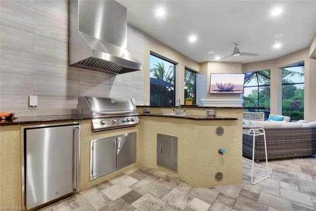 a kitchen with stainless steel appliances granite countertop a sink a stove and a refrigerator