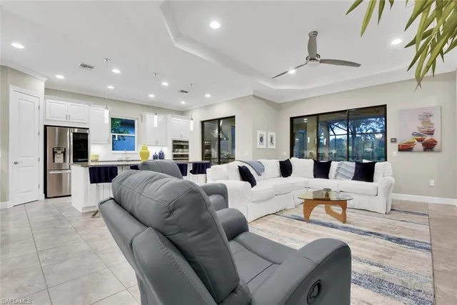 a living room with furniture kitchen view and a large window