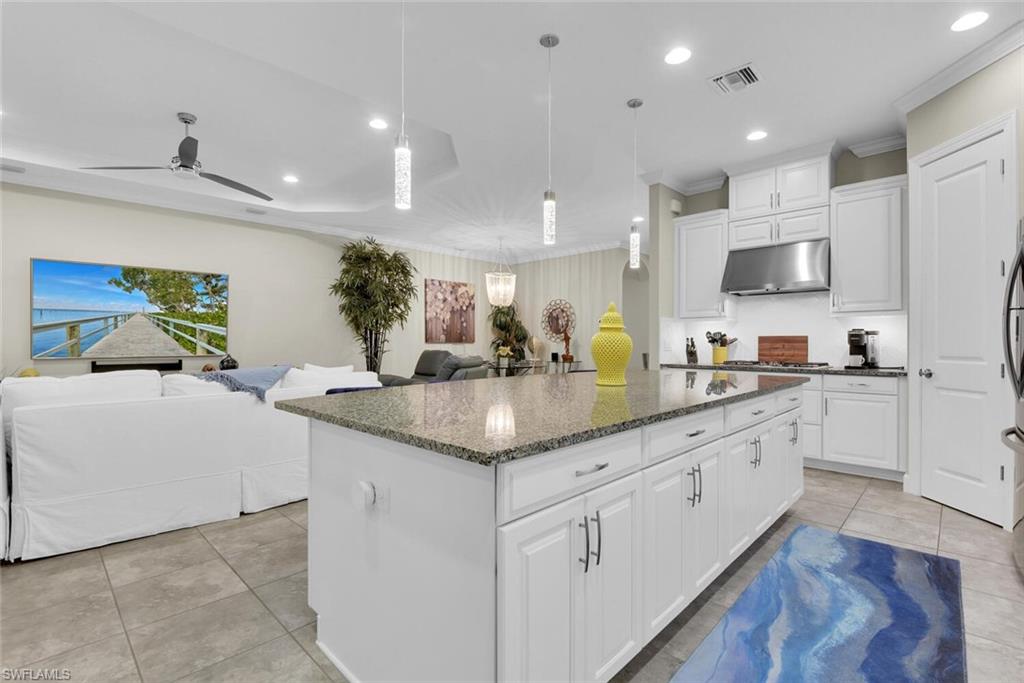 9630 Campanile Circle Naples, FL 34114 - Photo 7 of 31 a kitchen with granite countertop a sink and white cabinets