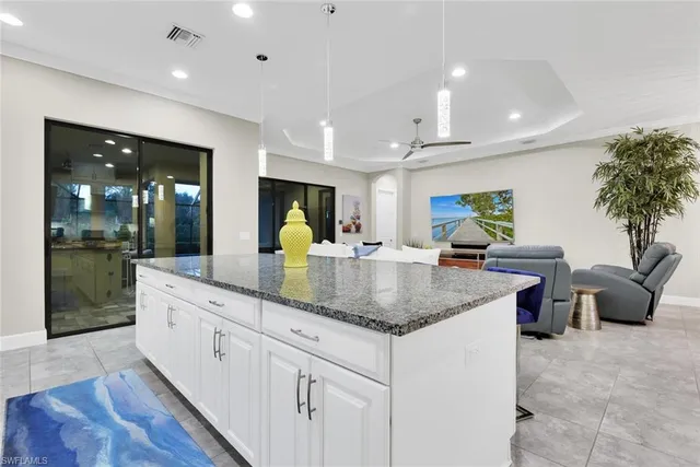 a kitchen with stainless steel appliances granite countertop a sink a counter top space and living room view
