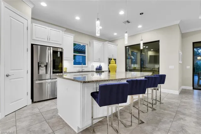 a kitchen with stainless steel appliances granite countertop a stove a sink a dining table and chairs