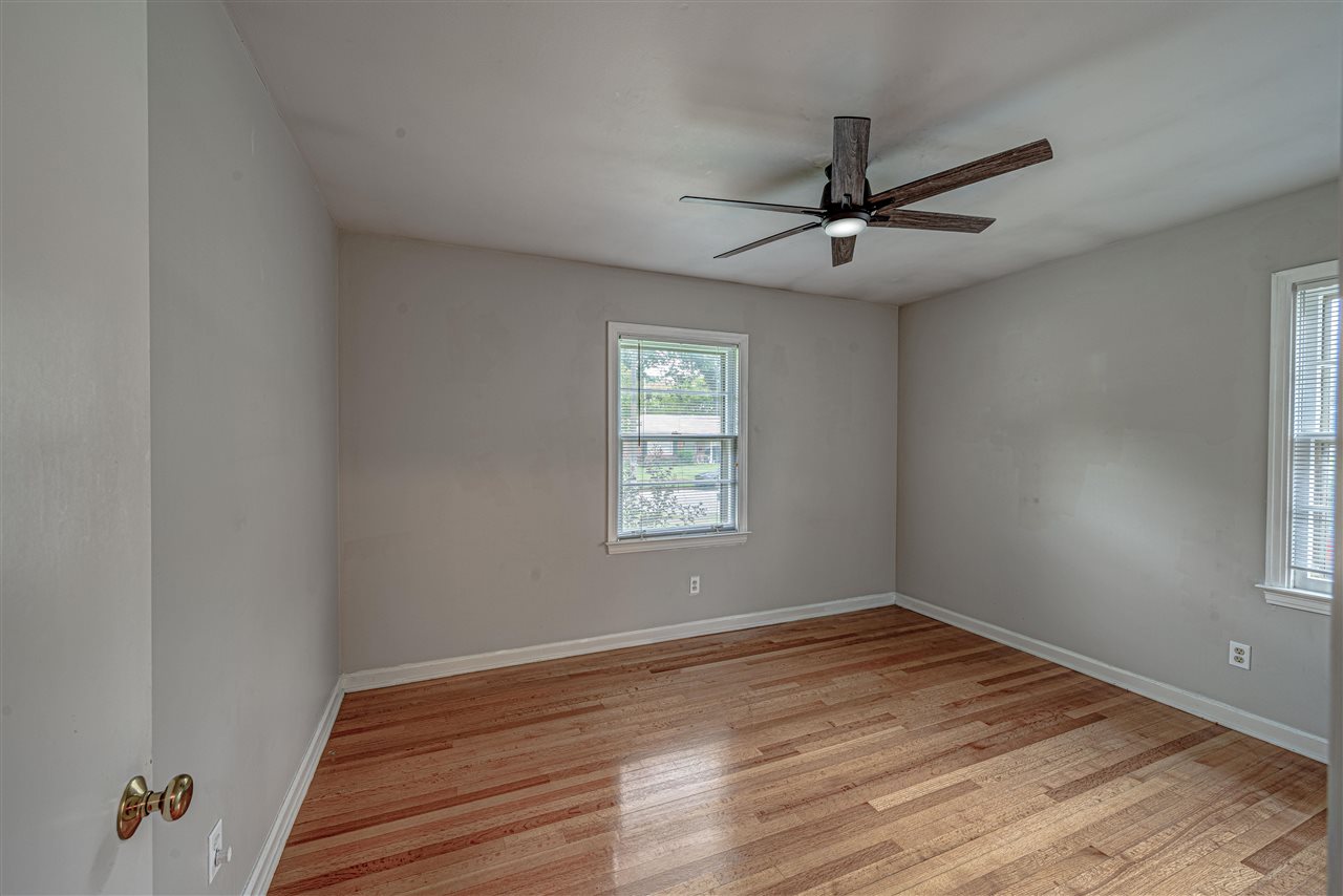 1645 Welsh Road Memphis, TN 38117 - Photo 15 of 18 an empty room with wooden floor ceiling fan and windows