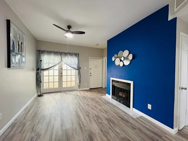wooden floor fireplace and windows in an empty room