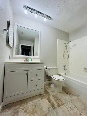 a bathroom with a toilet a sink a mirror and bathtub