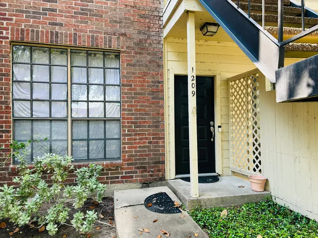 a view of a brick house with large windows