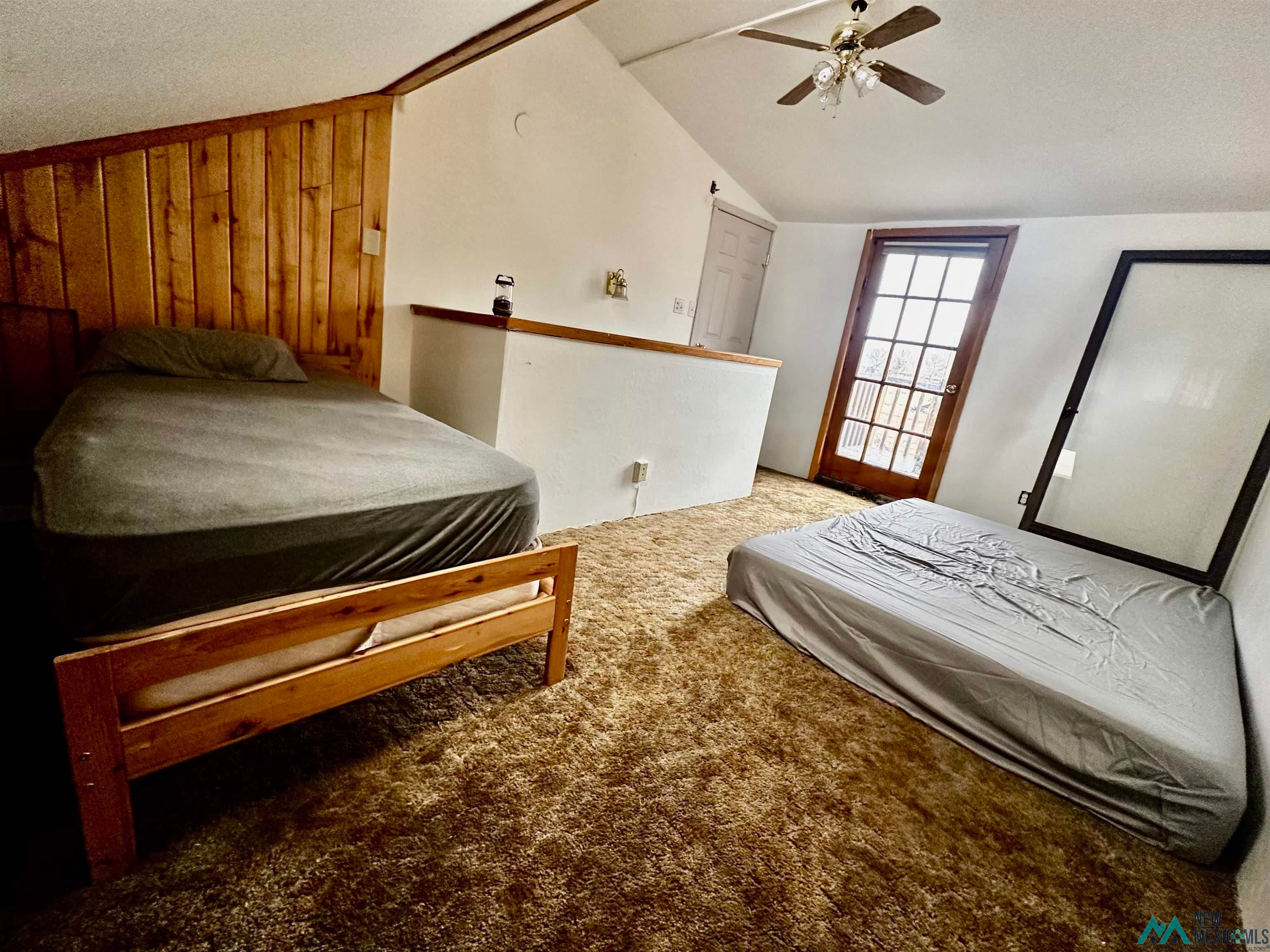 31 Bill Knight Gap Road Luna, NM 87824 - Photo 20 of 41 Carpeted bedroom with ceiling fan and wooden walls