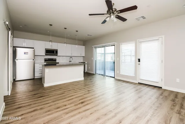 a view of kitchen with refrigerator microwave and stove top oven