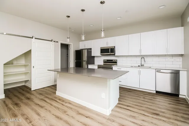 a kitchen with granite countertop white cabinets and stainless steel appliances
