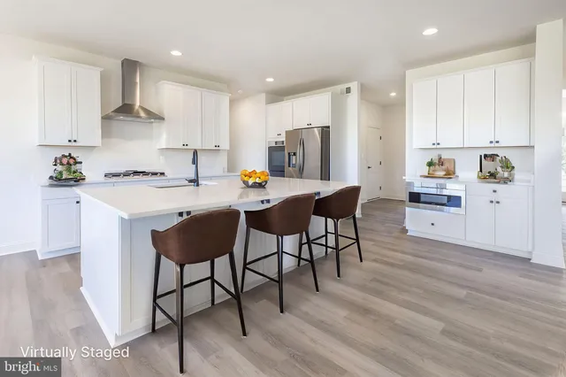 a kitchen with stainless steel appliances a table chairs refrigerator and wooden cabinets
