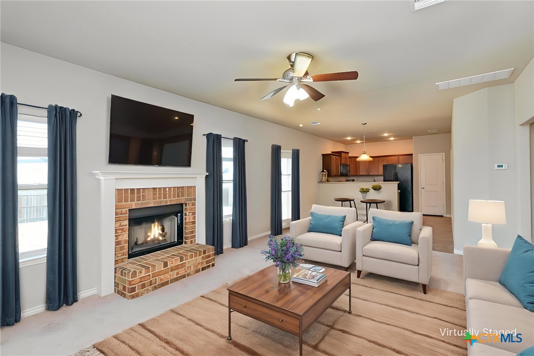 a living room with furniture a fireplace and a flat screen tv