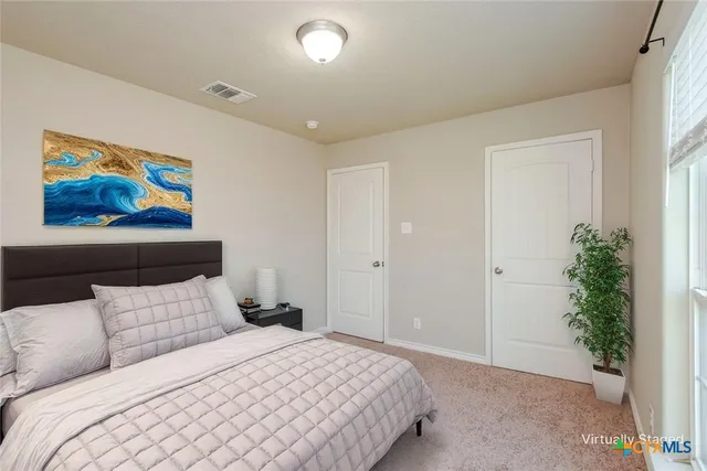 a bedroom with a large bed and a potted plant