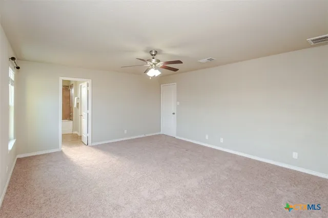 a view of an empty room with a ceiling fan