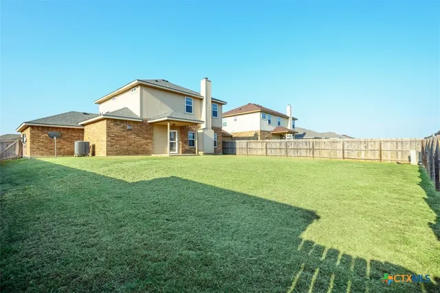 a view of a big house with a big yard and large trees