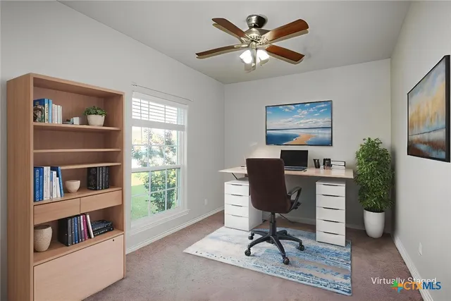 a view of a workspace with furniture and a window