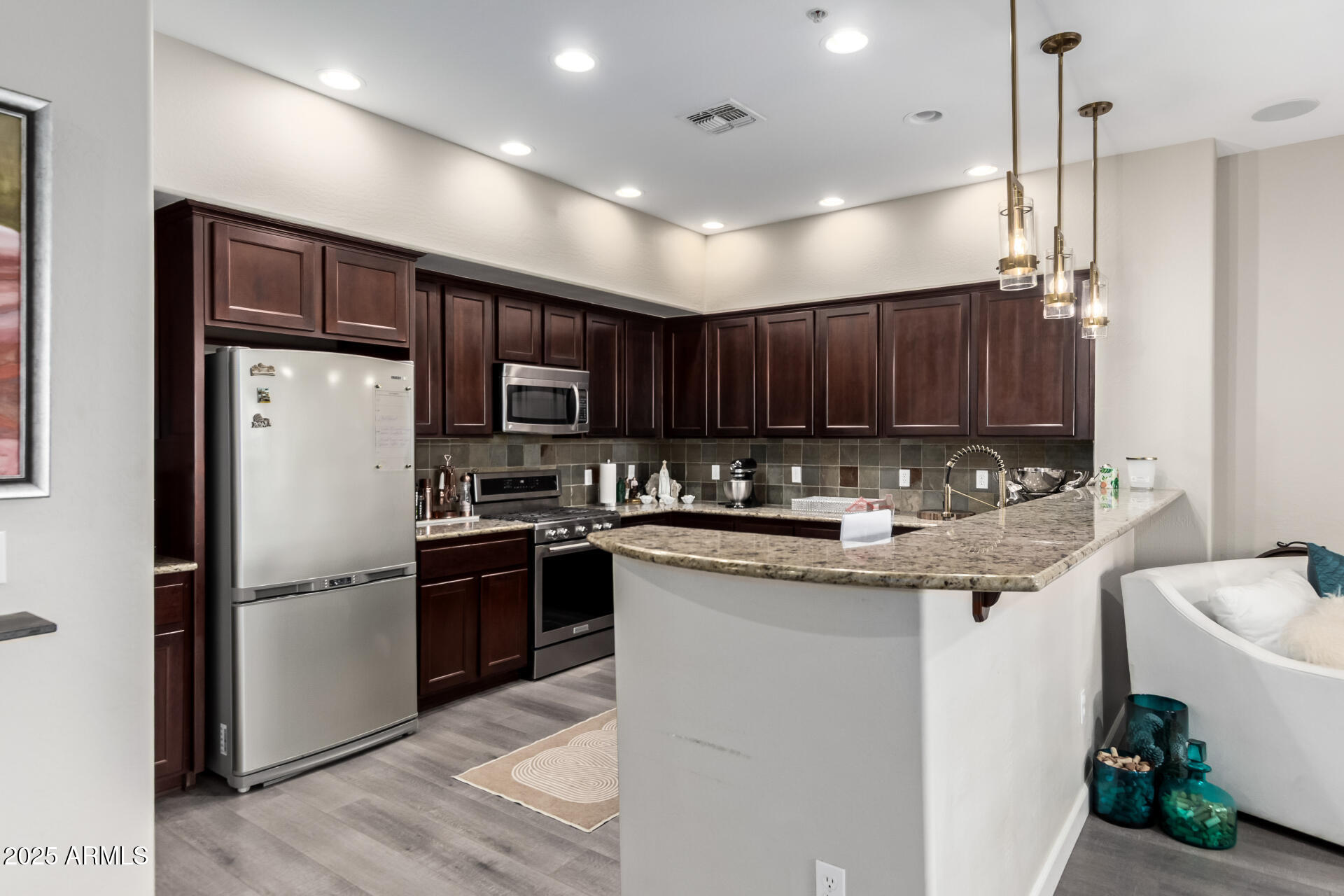 4777 South Fulton Ranch Boulevard, Unit 2035 Chandler, AZ 85248 - Photo 11 of 38 a kitchen with stainless steel appliances granite countertop a refrigerator a sink dishwasher a stove with wooden cabinets and floors