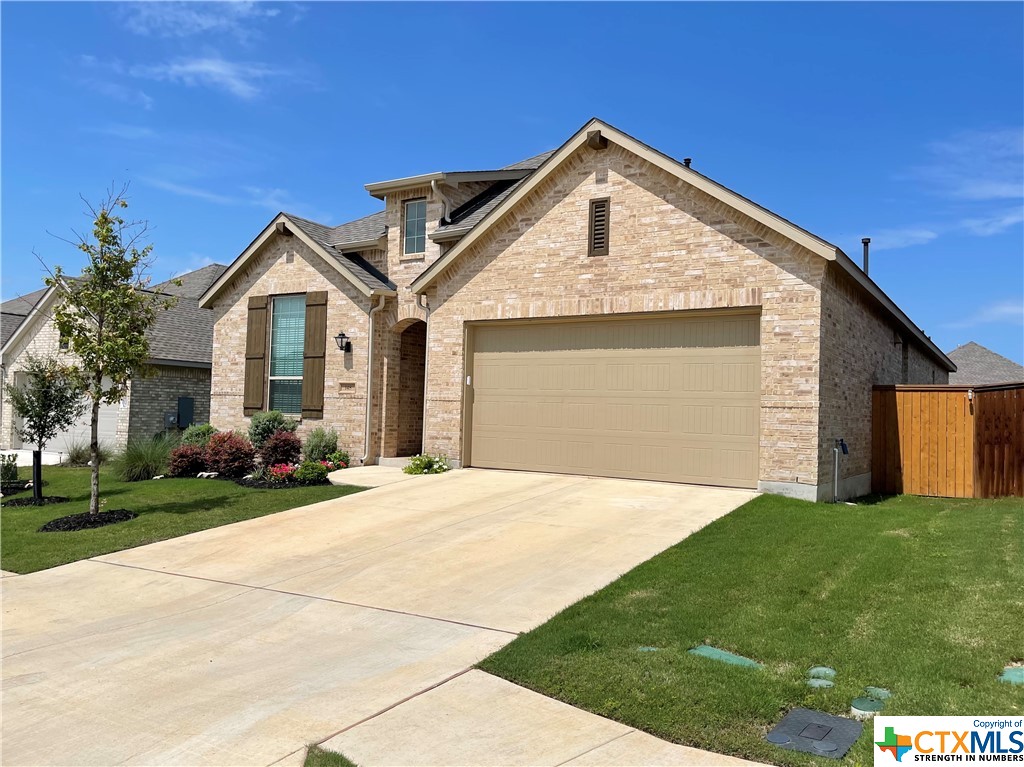 a front view of a house with a garden and yard