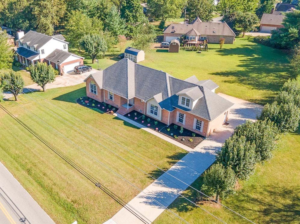 an aerial view of residential houses with outdoor space and swimming pool
