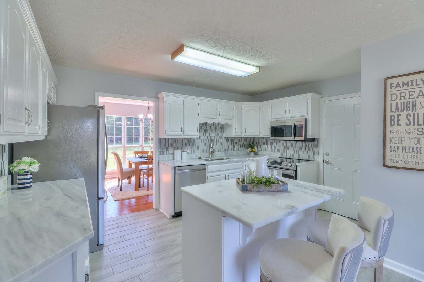 2891 Sulphur Springs Road Murfreesboro, TN 37129 - Photo 12 of 31 a kitchen with stainless steel appliances kitchen island granite countertop a table chairs and a refrigerator