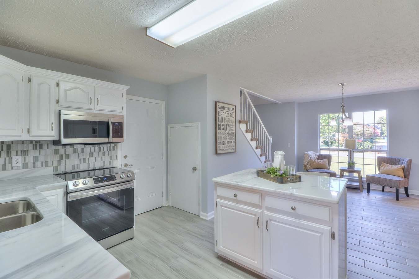 2891 Sulphur Springs Road Murfreesboro, TN 37129 - Photo 15 of 31 a kitchen with stainless steel appliances white cabinets a stove a sink a dining table and chairs