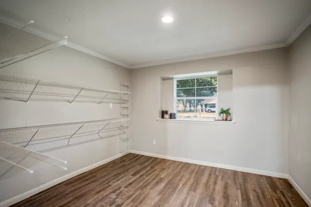 a view of a room with wooden floor and windows