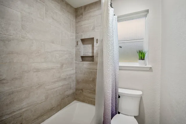 a bathroom with a toilet and shower