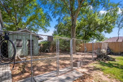 a front view of a house with a garden and trees