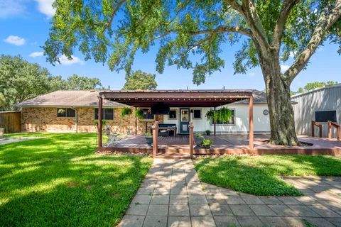 a view of a house with a yard patio and tree