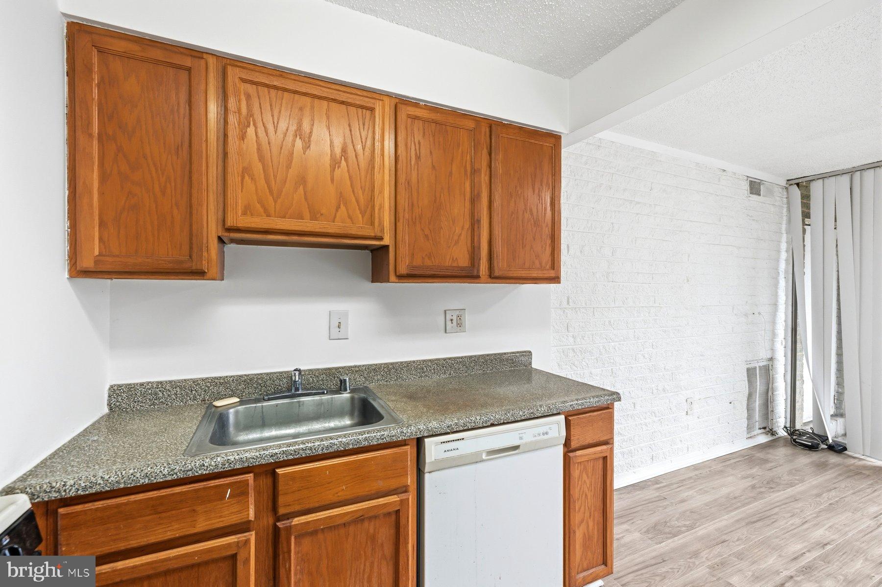 1824 Metzerott Road, Unit 203 Hyattsville, MD 20783 - Photo 12 of 19 a kitchen with granite countertop wood cabinets stainless steel appliances and a sink