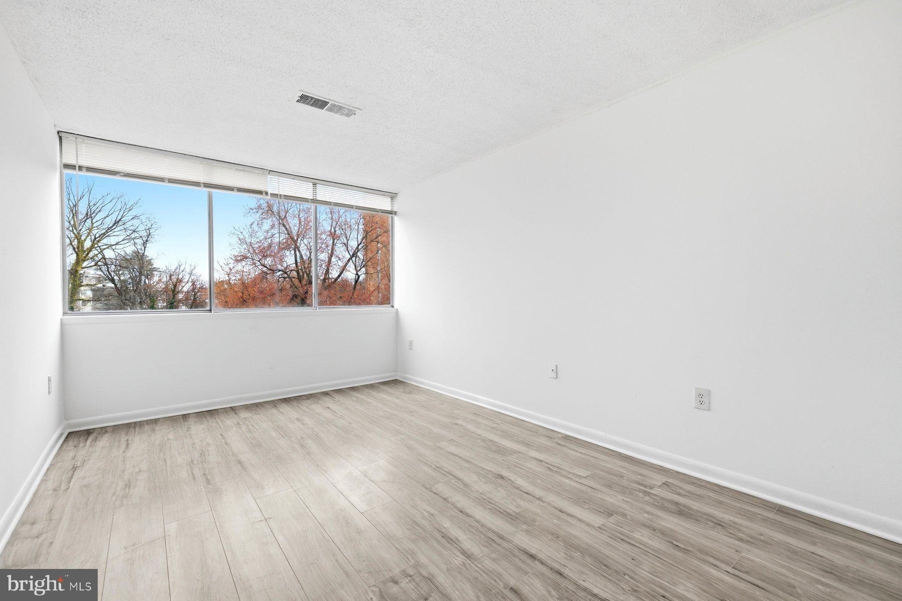 1824 Metzerott Road, Unit 203 Hyattsville, MD 20783 - Photo 15 of 19 a view of empty room with wooden floor and fan