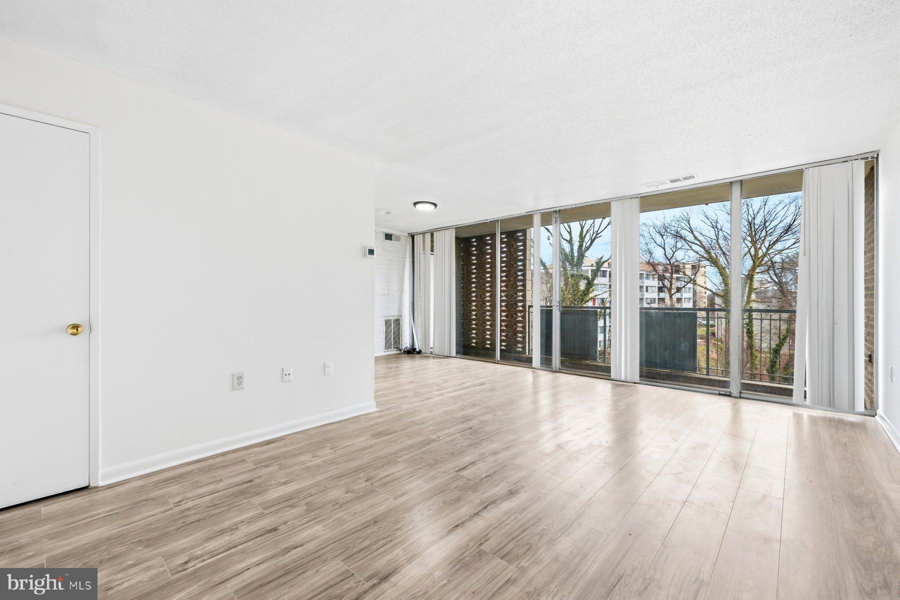 1824 Metzerott Road, Unit 203 Hyattsville, MD 20783 - Photo 3 of 19 a view of an empty room with wooden floor and a window