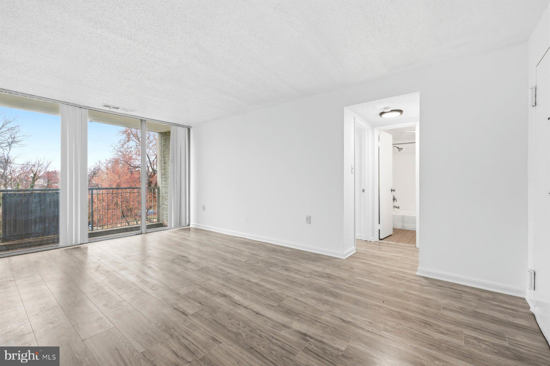 1824 Metzerott Road, Unit 203 Hyattsville, MD 20783 - Photo 4 of 19 an empty room with wooden floor and windows