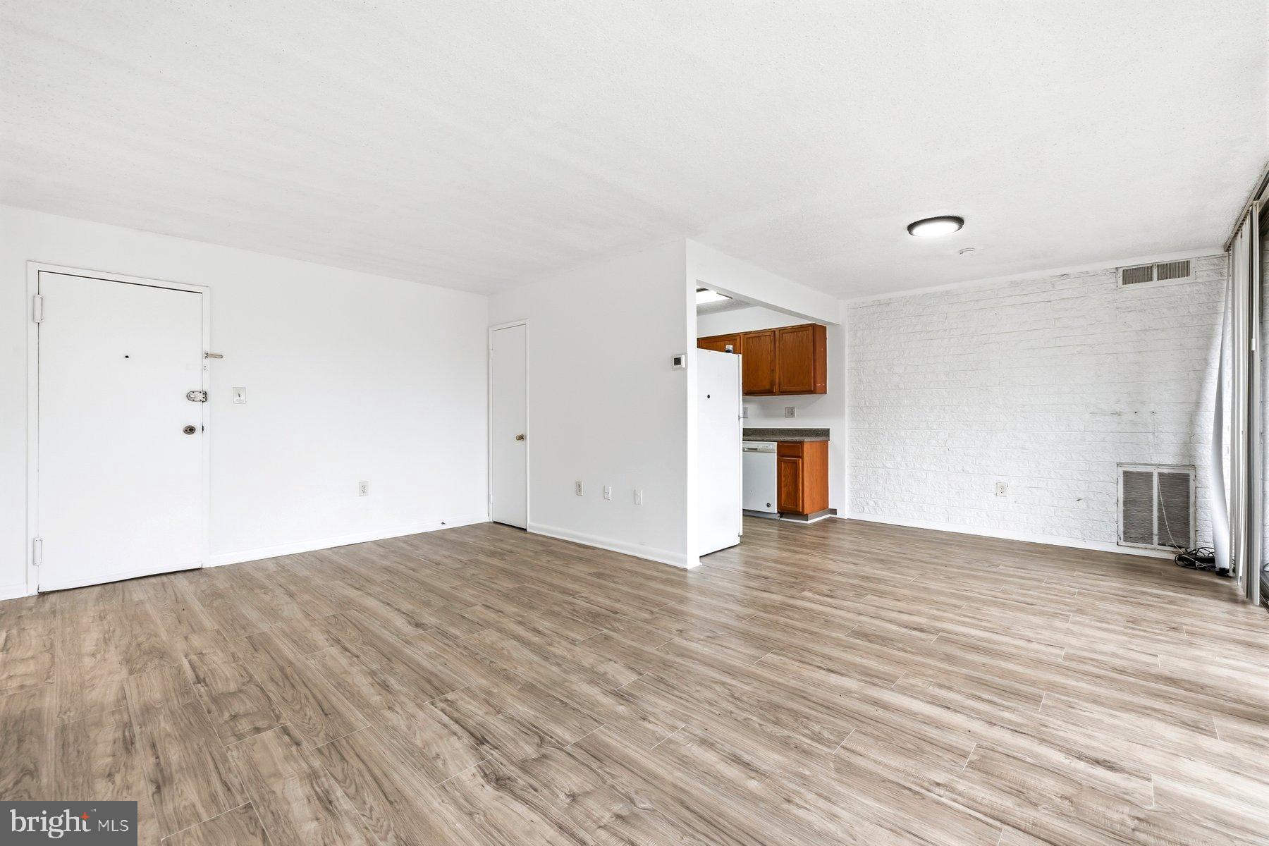 1824 Metzerott Road, Unit 203 Hyattsville, MD 20783 - Photo 5 of 19 a view of empty room with wooden floor and fireplace