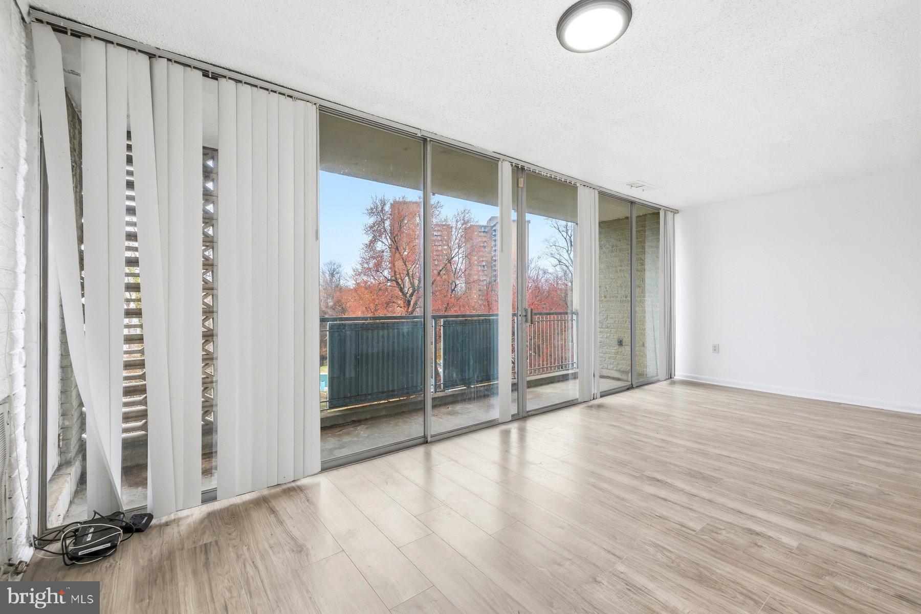 1824 Metzerott Road, Unit 203 Hyattsville, MD 20783 - Photo 8 of 19 a view of an empty room with wooden floor and windows
