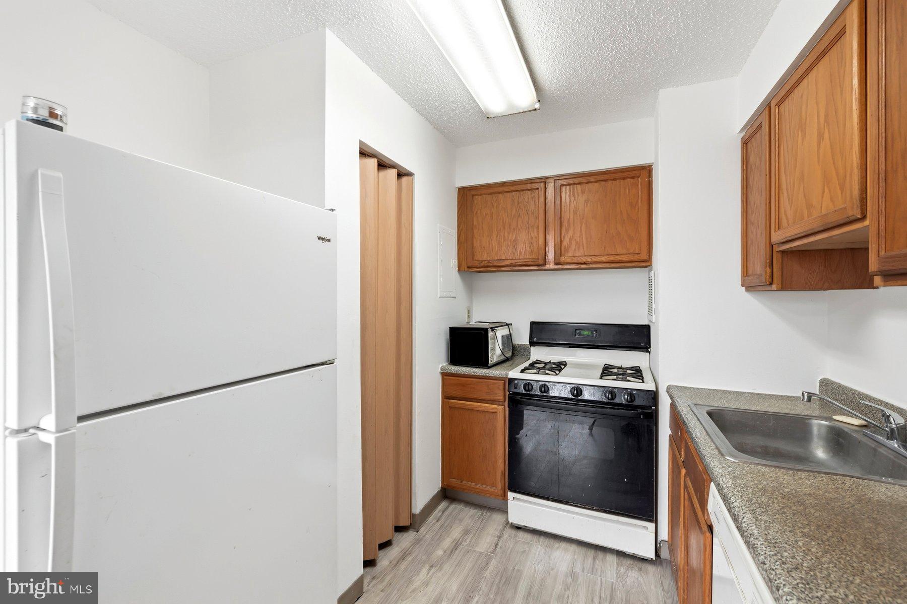 1824 Metzerott Road, Unit 203 Hyattsville, MD 20783 - Photo 9 of 19 a kitchen with a stove a refrigerator and a sink