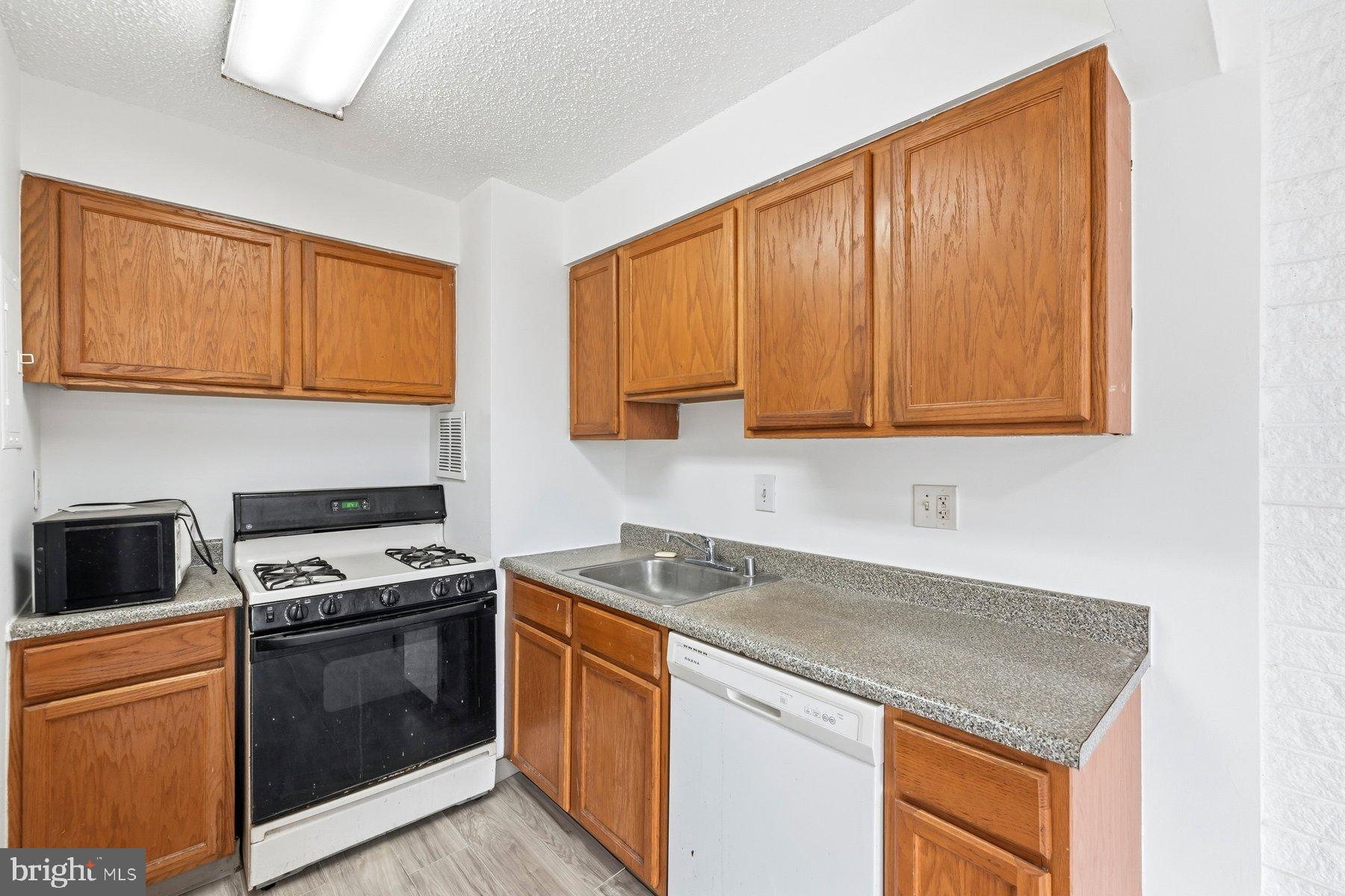 1824 Metzerott Road, Unit 203 Hyattsville, MD 20783 - Photo 10 of 19 a kitchen with stainless steel appliances granite countertop a stove a sink and a microwave