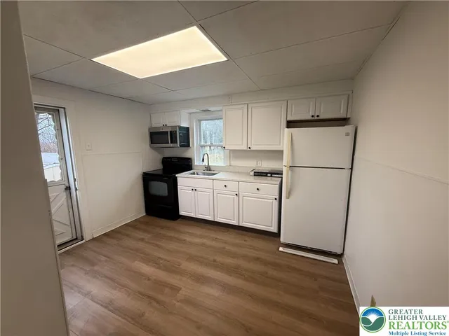a kitchen with a refrigerator a microwave and sink