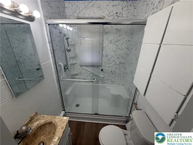 a bathroom with a granite countertop sink toilet and shower