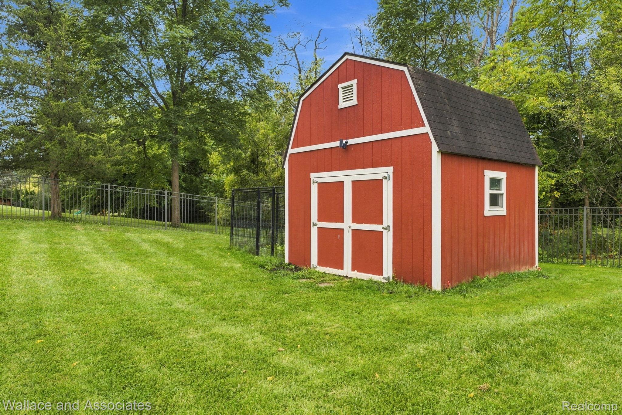 17076 27 Mile Road Ray, MI 48096 - Photo 63 of 63 Red barn-style shed with white trim, double doors, and a single window