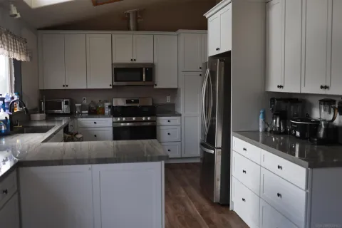 a kitchen with granite countertop white cabinets and stainless steel appliances