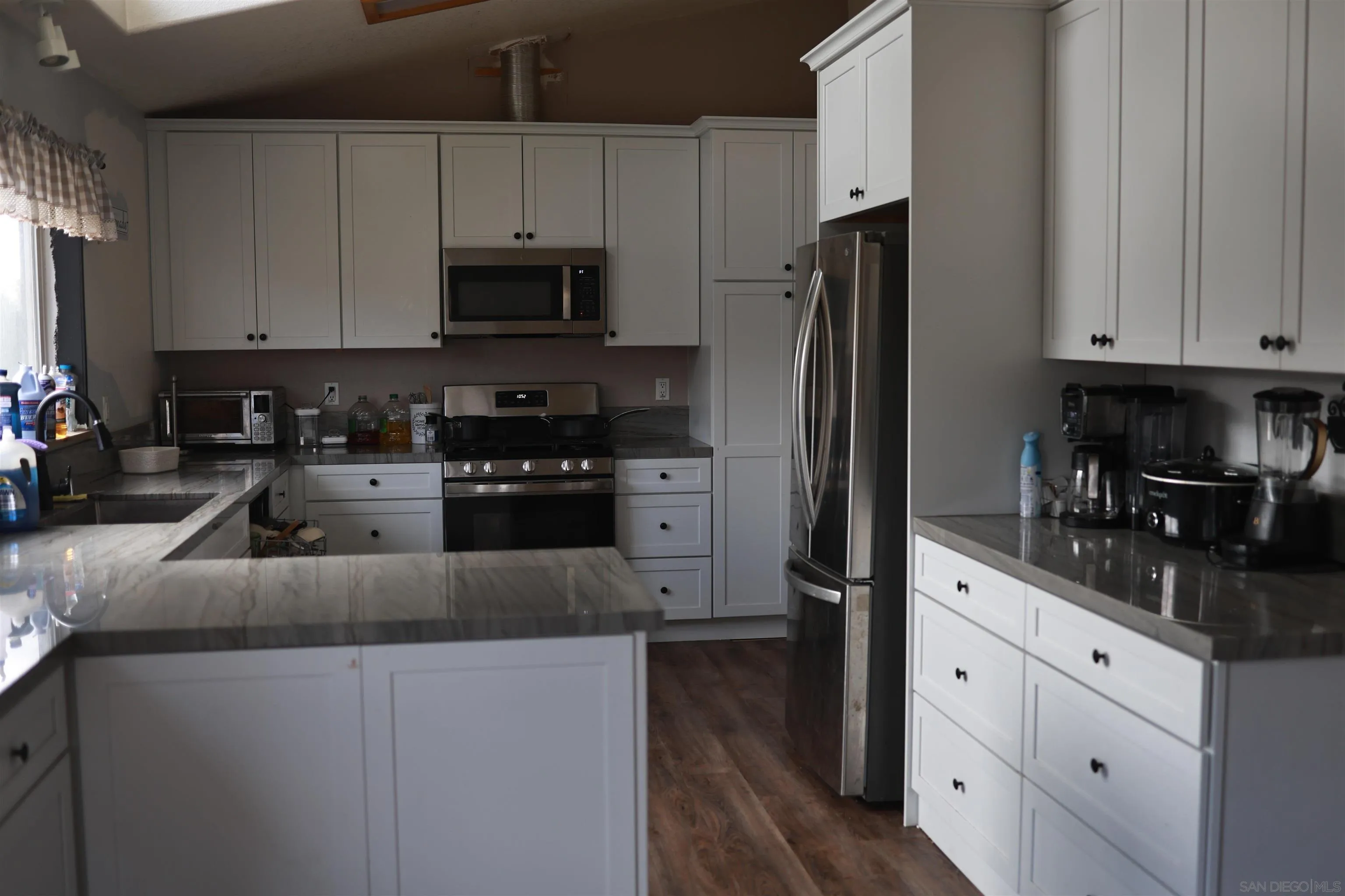 1122 Tierra Del Sol Road Boulevard, CA 91905 - Photo 12 of 26 a kitchen with granite countertop white cabinets and stainless steel appliances
