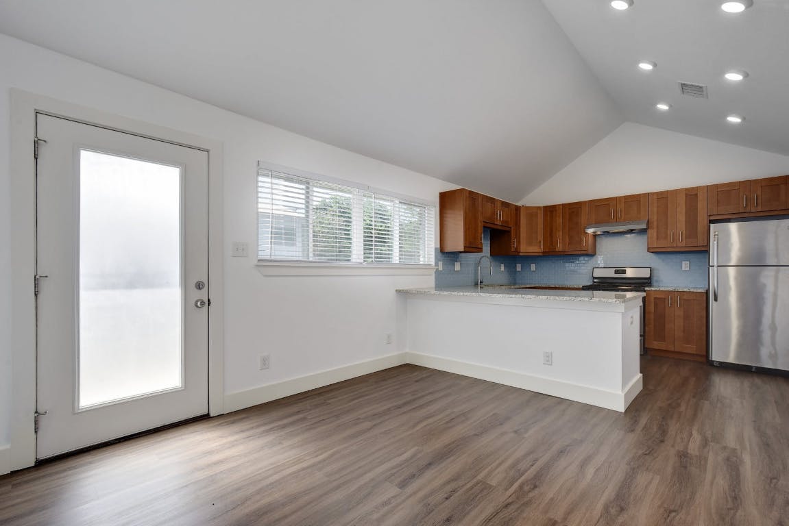 1311 East 52nd Street, Unit 3 Austin, TX 78723 - Photo 1 of 20 a kitchen with stainless steel appliances granite countertop a refrigerator and a stove top oven