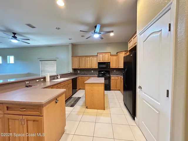 a kitchen with granite countertop a sink a counter top space stainless steel appliances and cabinets