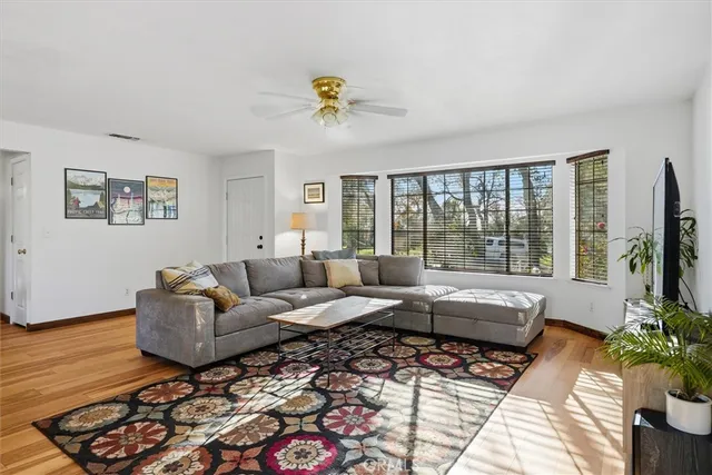 a living room with furniture kitchen view and a large window