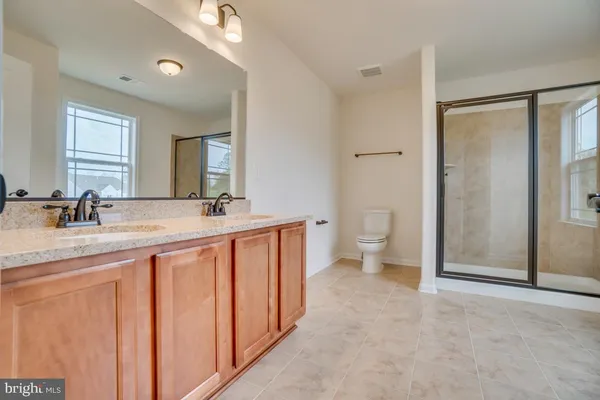 a spacious bathroom with a granite countertop sink toilet and shower