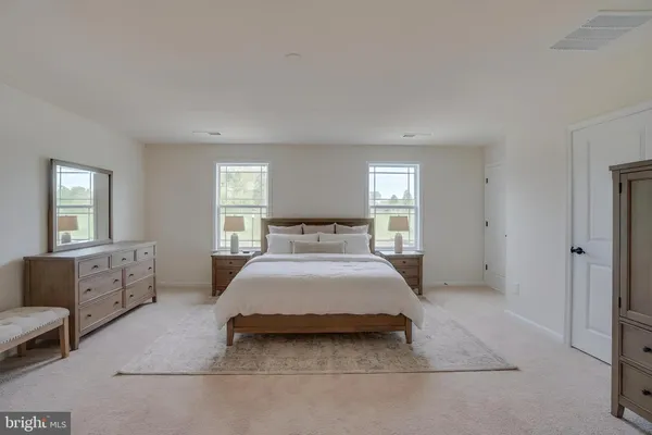 a spacious bedroom with a bed and window