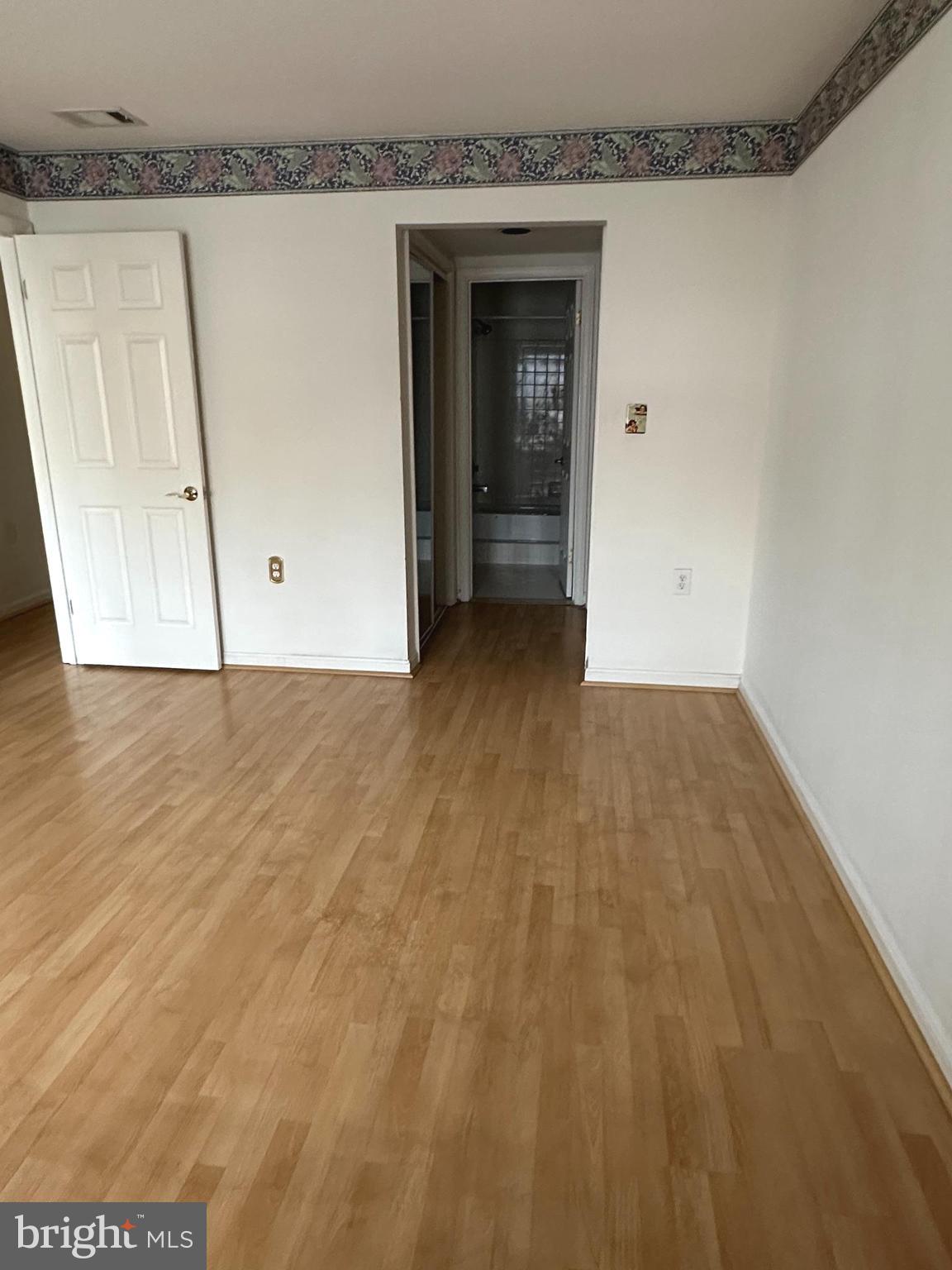 7808 Spinnaker Road, Unit 12 Laurel, MD 20707 - Photo 15 of 23 a view of an empty room with wooden floor and a cabinet