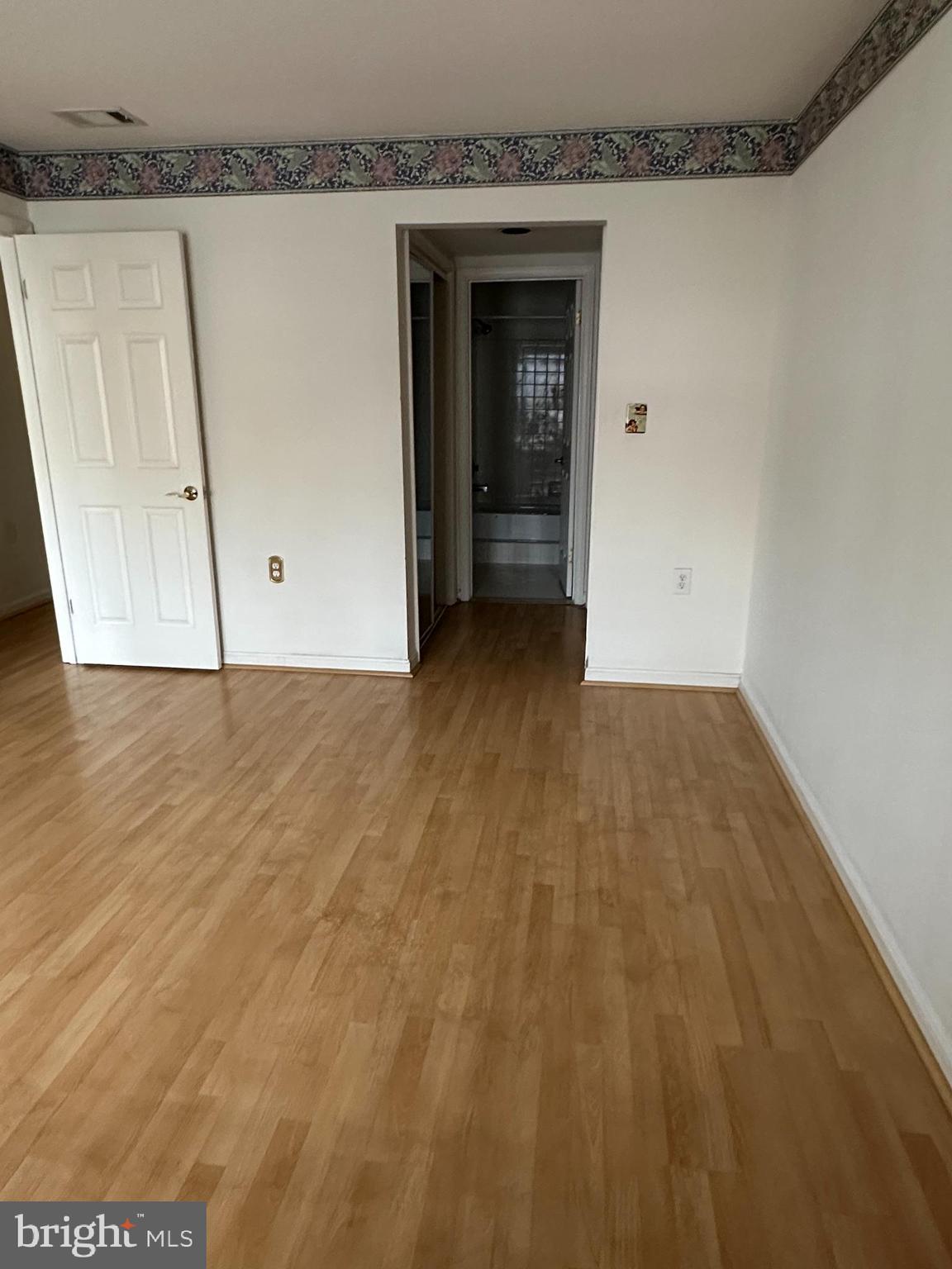 7808 Spinnaker Road, Unit 12 Laurel, MD 20707 - Photo 16 of 23 a view of an empty room with wooden floor and a cabinet